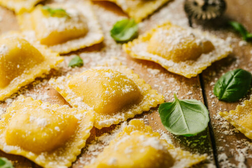 Tasty,Raw,Ravioli,With,Flour,And,Basil,On,Wooden,Background.